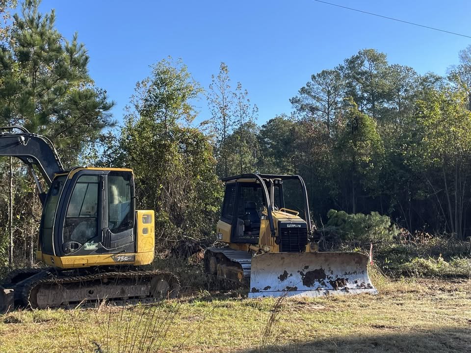 Allen Land Services excavator and dozer on a cleared lot at the tree line