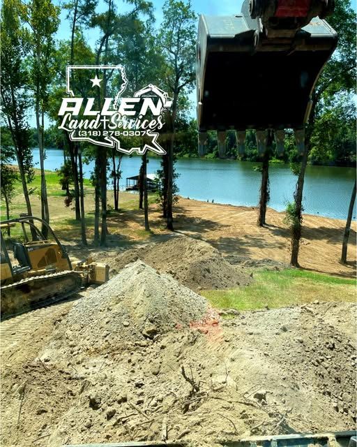 Dozer and a pile of dirt on a lakeside lot under pine trees